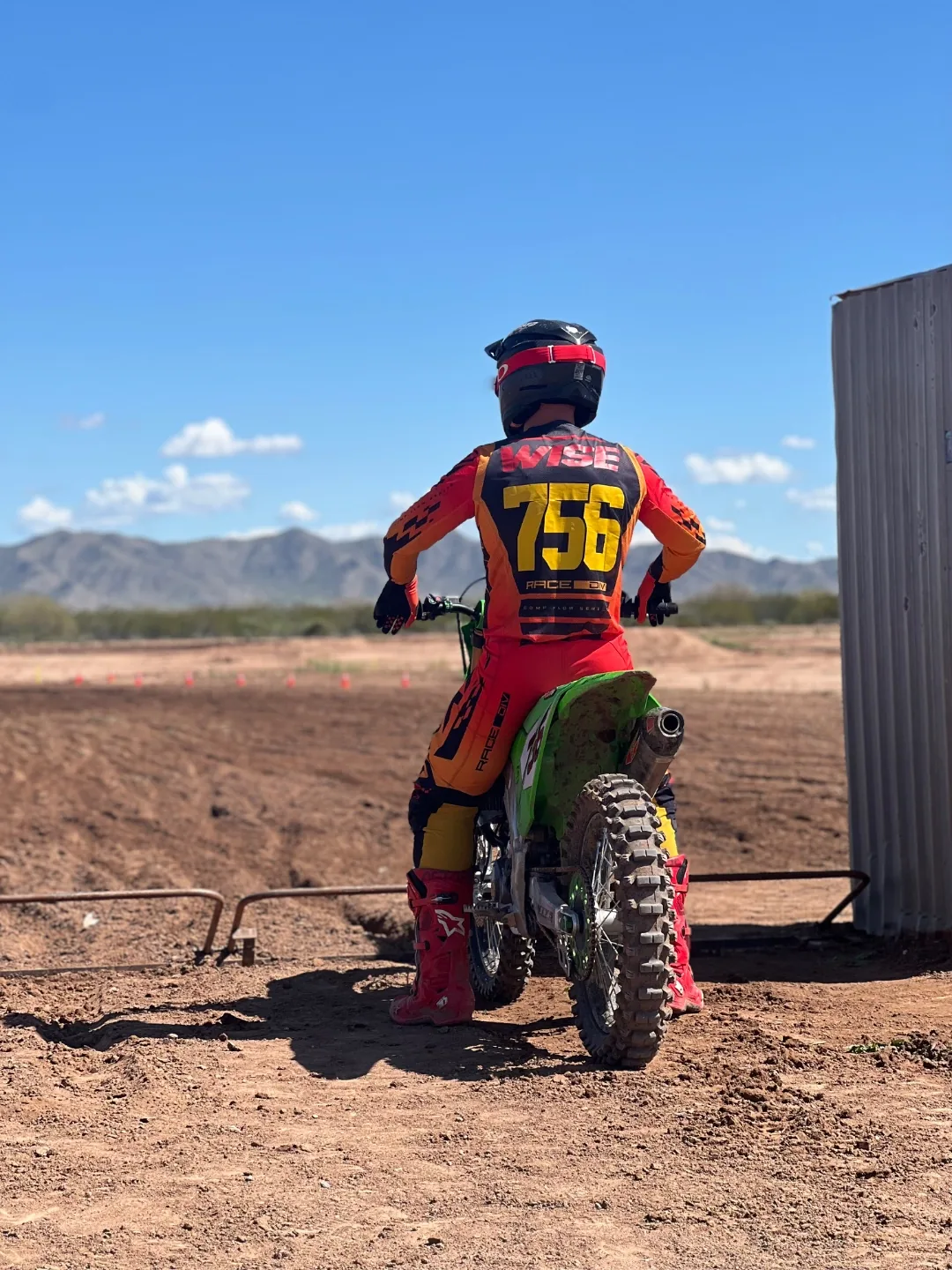 Rider number 756 sitting on a dirt bike facing the open desert track