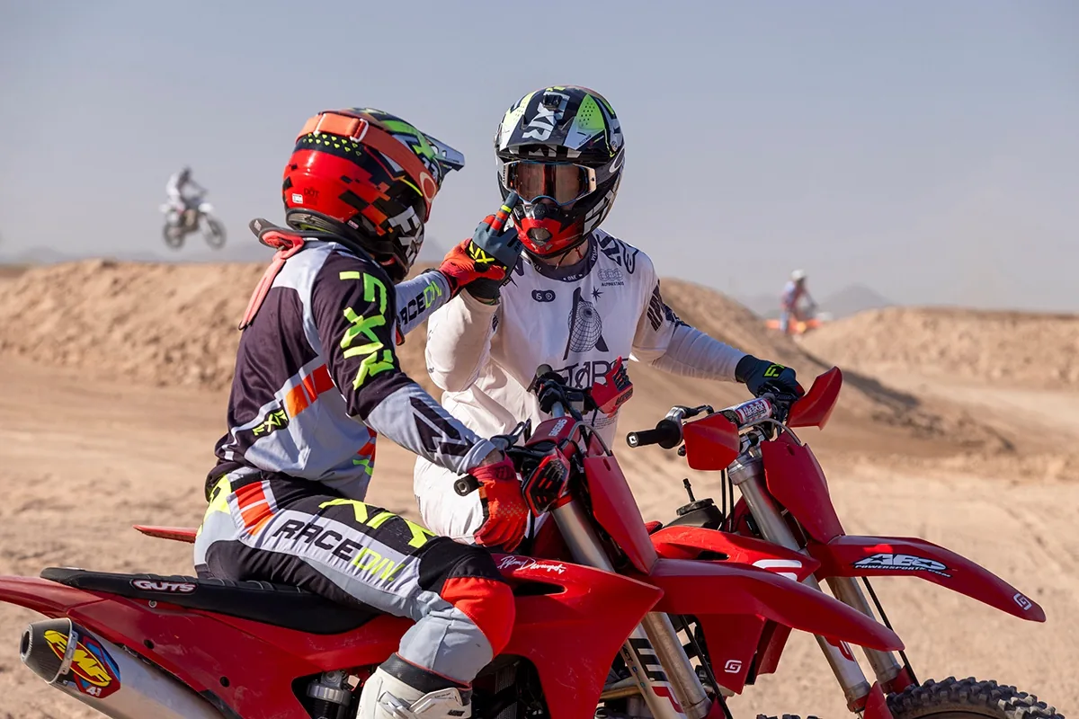 Two riders sharing a fist bump on their bikes before a ride